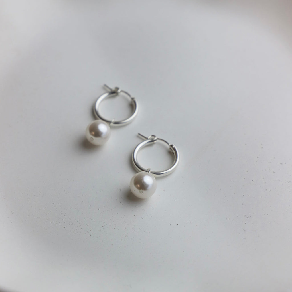 Get ready to add some pizzazz to your outfit with our Audrey Pearl Hoop Earrings in silver. These hoops feature stylish pearls, adding a touch of elegance to your look. Perfect for a night out or to dress up your everyday style. Small hoop is 2x13mm