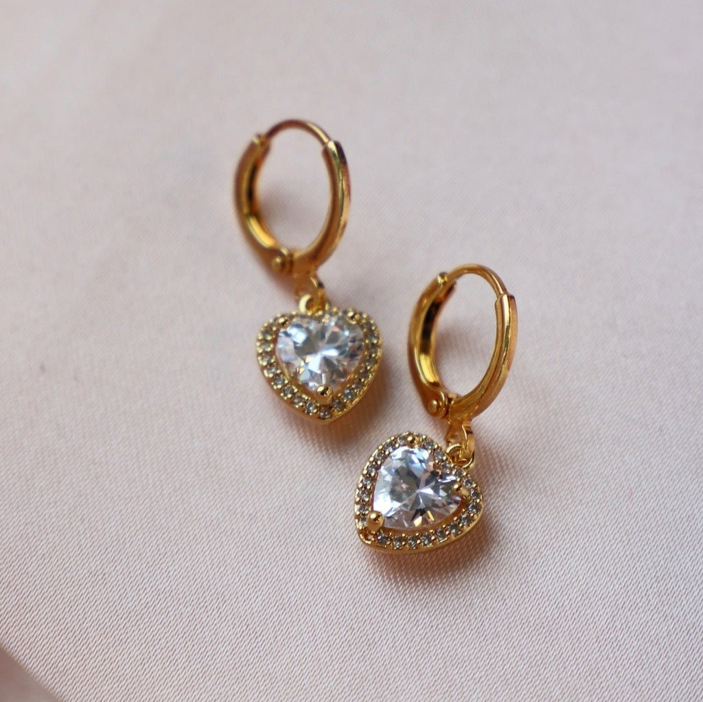 These elegant and timeless earrings feature sparkling CZ pave hearts, adding a touch of romance to any outfit. Crafted with precision and quality, these huggie earrings are perfect for any occasion.