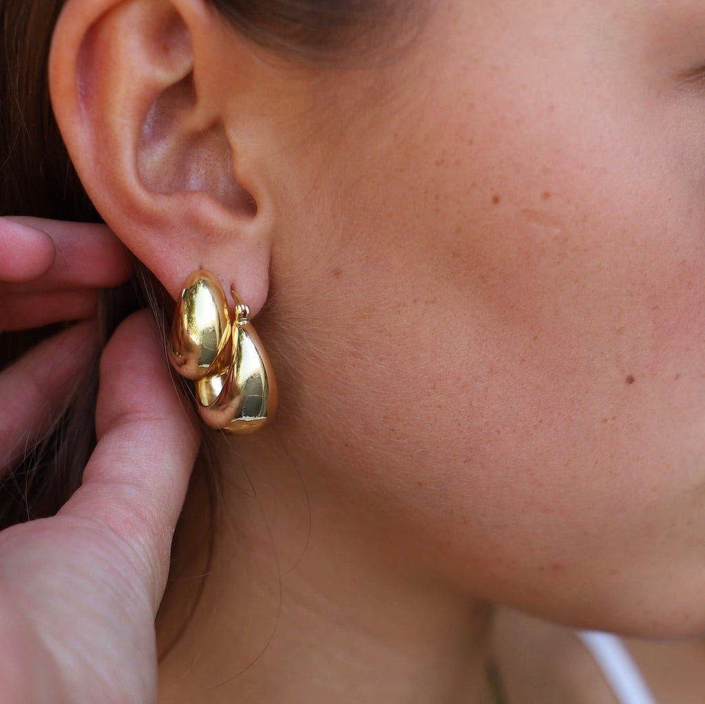 Add a touch of glamour to your look with these Coco Chunky Hoop Earrings. With a thick gold hoop design and a bold shape, these earrings add a touch of sophistication to any outfit.