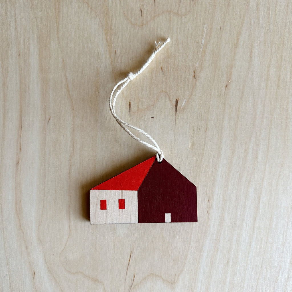 wooden house ornament with a red roof and windows and maroon wall