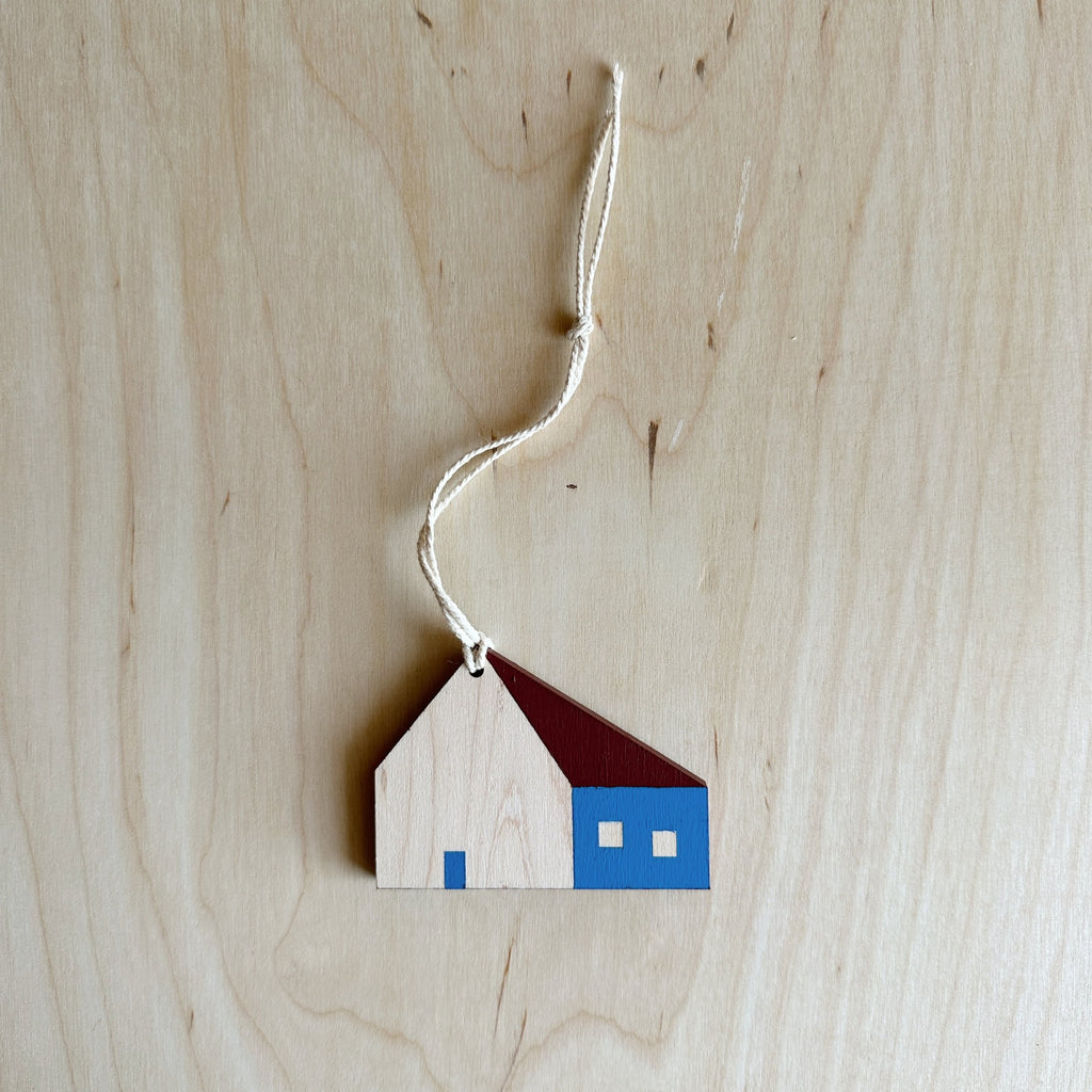 wooden house ornament with maroon roof and blue door and wall