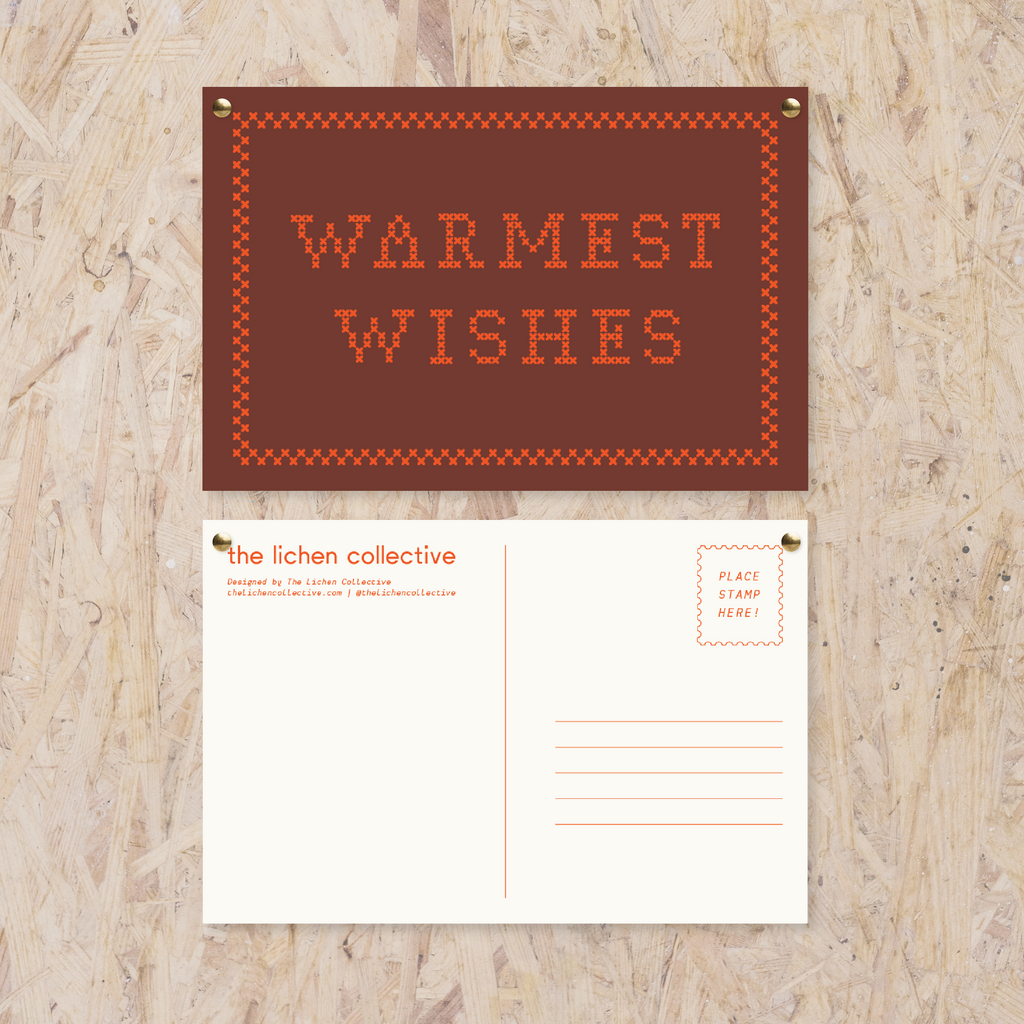 maroon postcard reading "warmest wishes" in a red cross stitch-like font in red