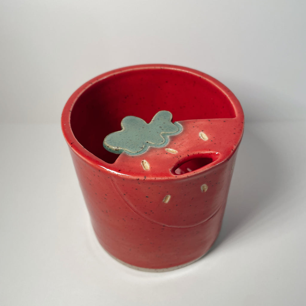 red ceramic sipper mug with strawberry design