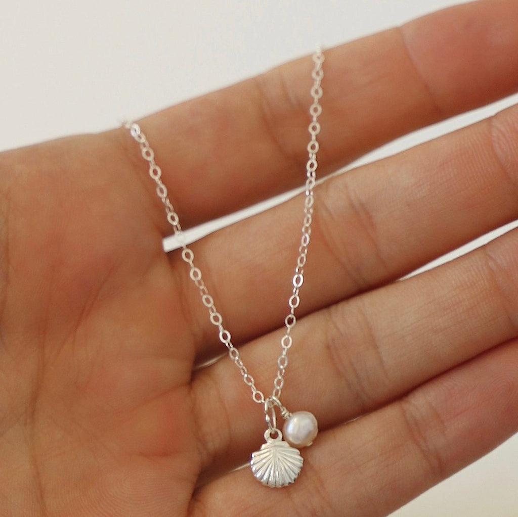 The Kai Necklace. A golden seashell necklace adorned with a pearl. It's an eye-catching piece that will bring a touch of sea inspired beauty to any look. It's classic simplicity is sure to last you all Summers to come. In Silver