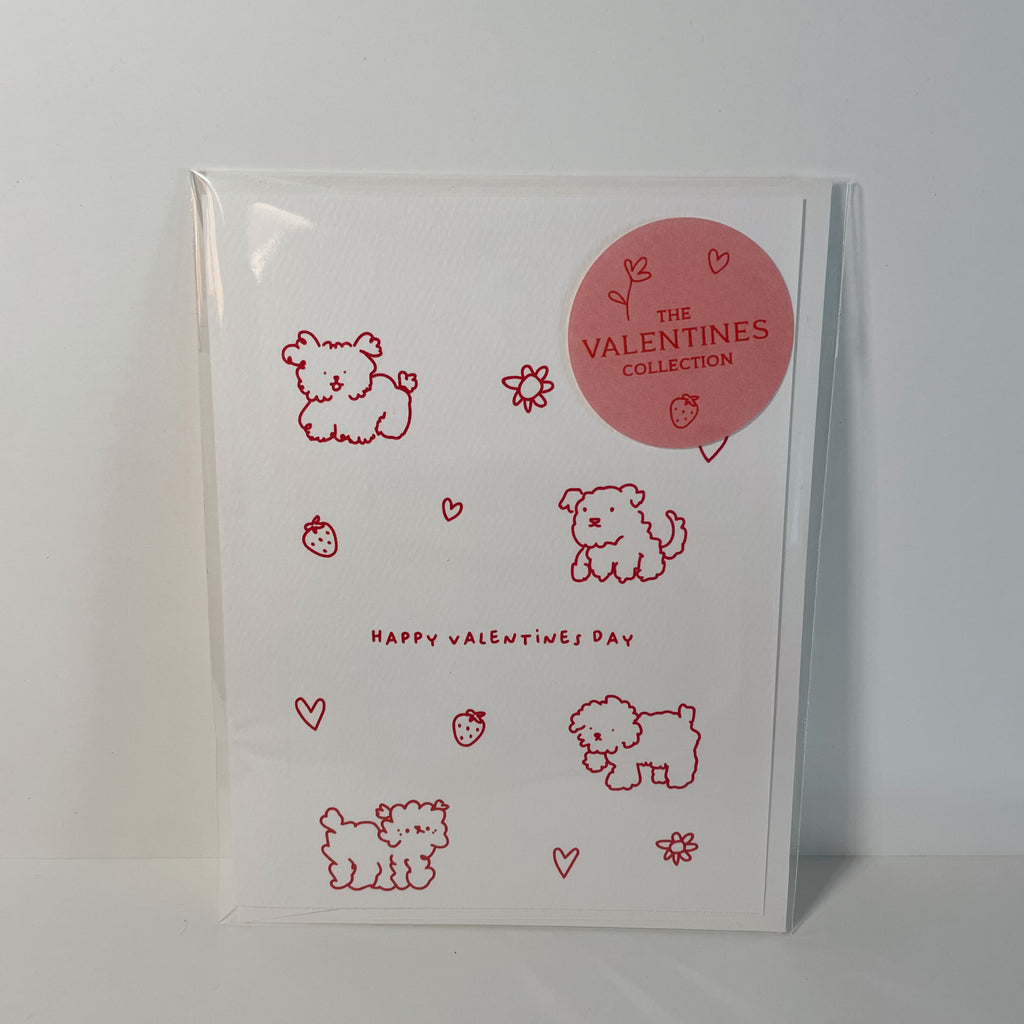 white valentine's card with red doodles of dogs, hearts, flowers, and strawberries