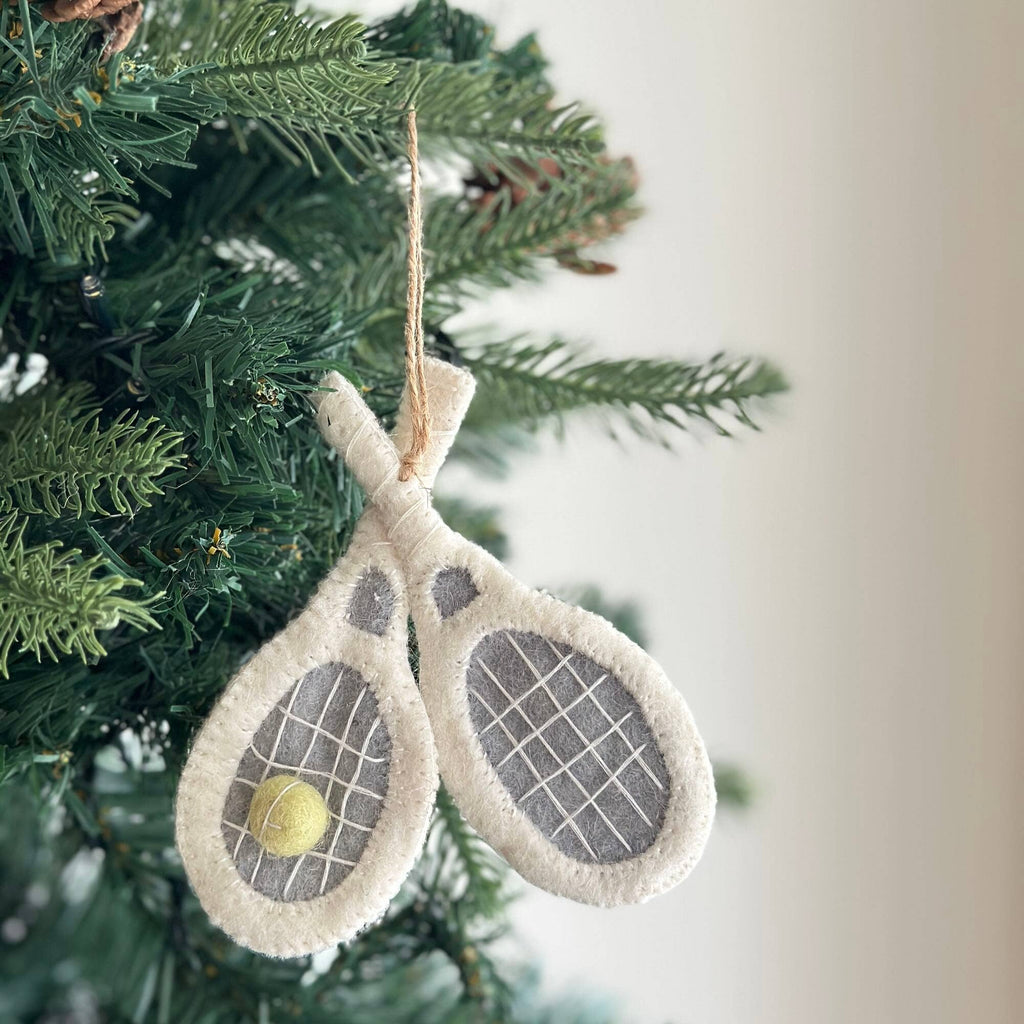 Introducing our Felt Tennis Racket Ornament! Crafted with care, this delightful decoration features two white tennis rackets elegantly crossing each other, cradling a tennis ball in the center. It's the ideal gift for tennis enthusiasts, adding a touch of sporty charm to any holiday decor. Whether adorning your tree or gifting to a friend, this ornament serves as a timeless tribute to the love of tennis.