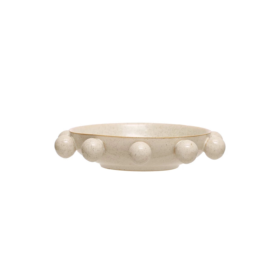 This bowl is anything but dull! Made of durable stoneware, it features a unique reactive glaze in a speckled cream color. The orbs add a playful touch, making it a fun and functional addition to any kitchen.