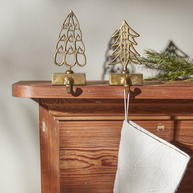 Hang the stockings by the chimney with care from the Alsace Stocking Holder. This vintage-inspired piece is made from antique gold metal with charming teardrop shapes arranged into a Christmas tree, a hook &amp; a weighty base to hold stockings securely.