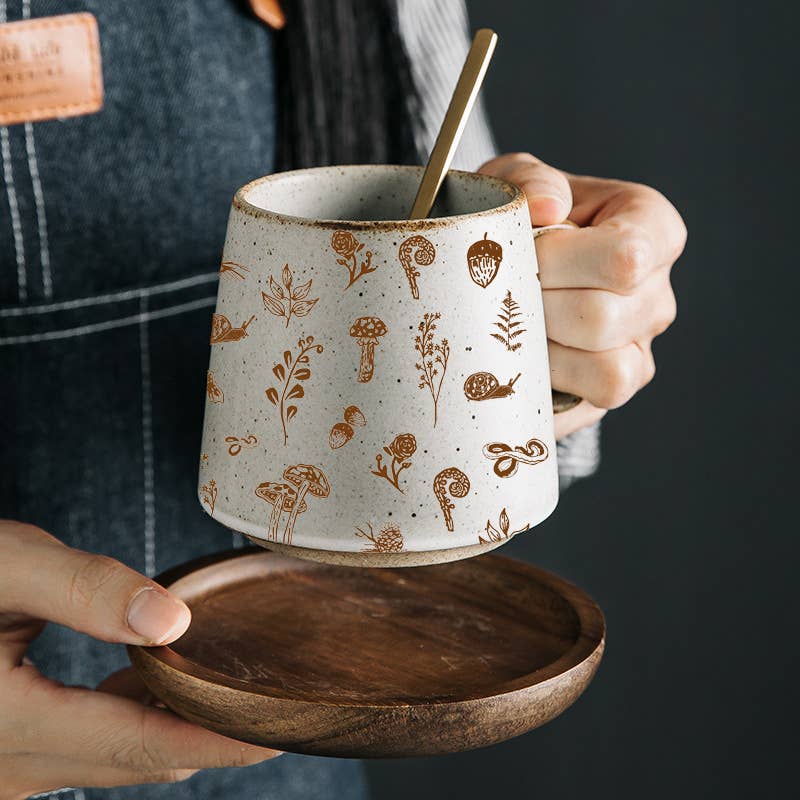 Bring the magic of the forest to your customers with our Woodland Stoneware Mug, a beautifully crafted piece that blends nature-inspired design with exceptional quality.

Featuring originally hand-drawn illustrations of woodland creatures and flora—like a snake, fern, acorn, and mushroom—this mug transports every sip to a tranquil forest setting.