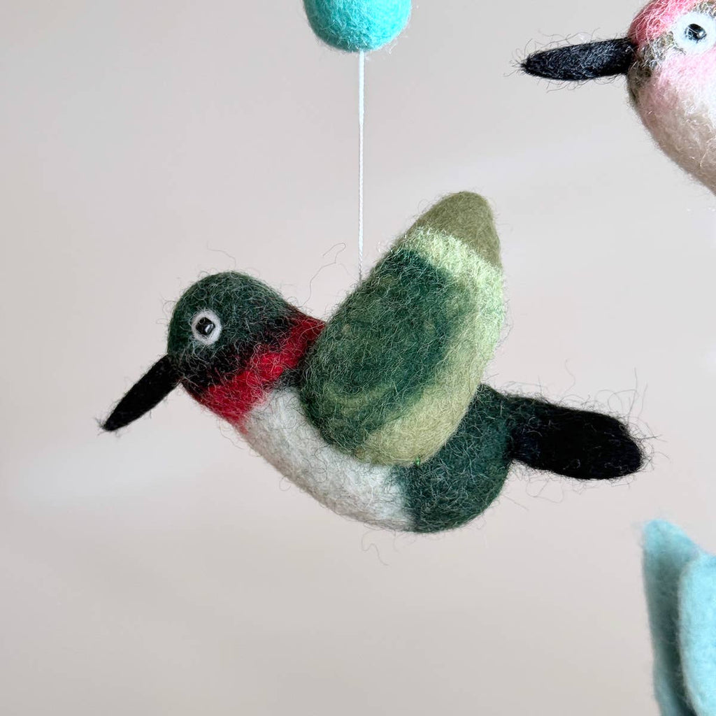 Discover our vibrant Hummingbird Baby Mobile!  Five colorful hummingbirds with dynamic wing positions dance around a white felt frame. Add a pop of brilliance and wonder to your space. A must-have for bird lovers, bringing nature's beauty right to your baby's eyes. Let imagination take flight!