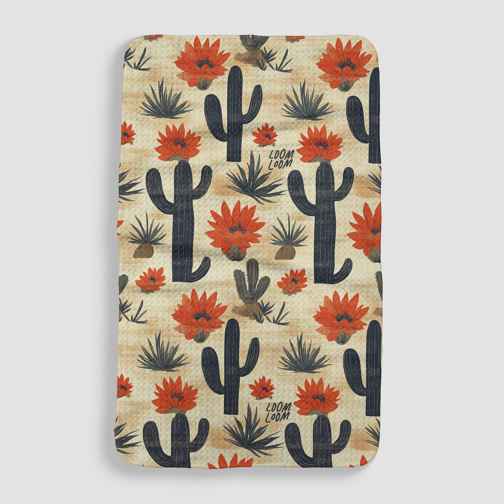 tan tea towel featuring a desert of varying cacti with red flowers