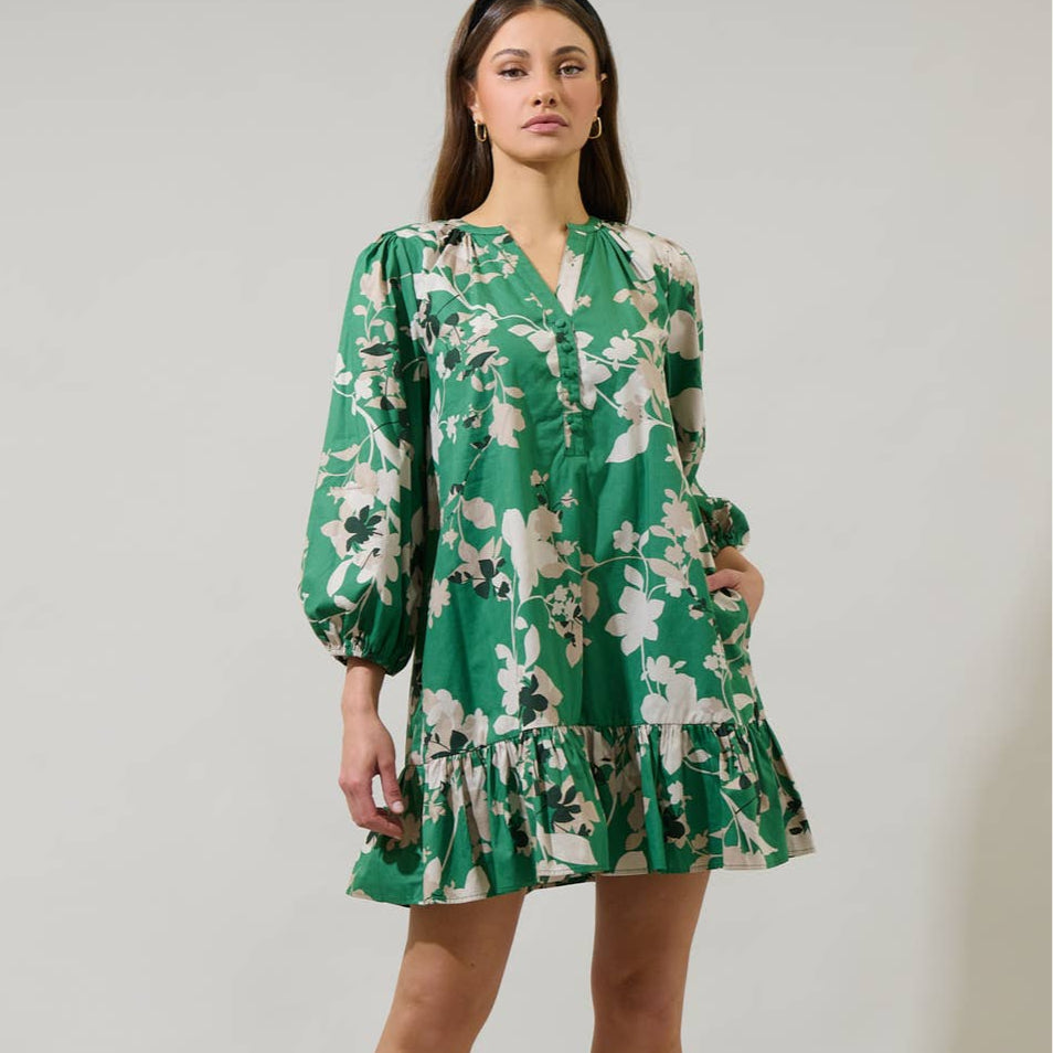 You'll be more than ready when you wear the Nora Floral Whine Shift Mini Dress. A split neckline frames long balloon sleeves with elastic bands at the end. It has a shift style with a ruffle hem at the bottom. Easy to pair with strappy heels.