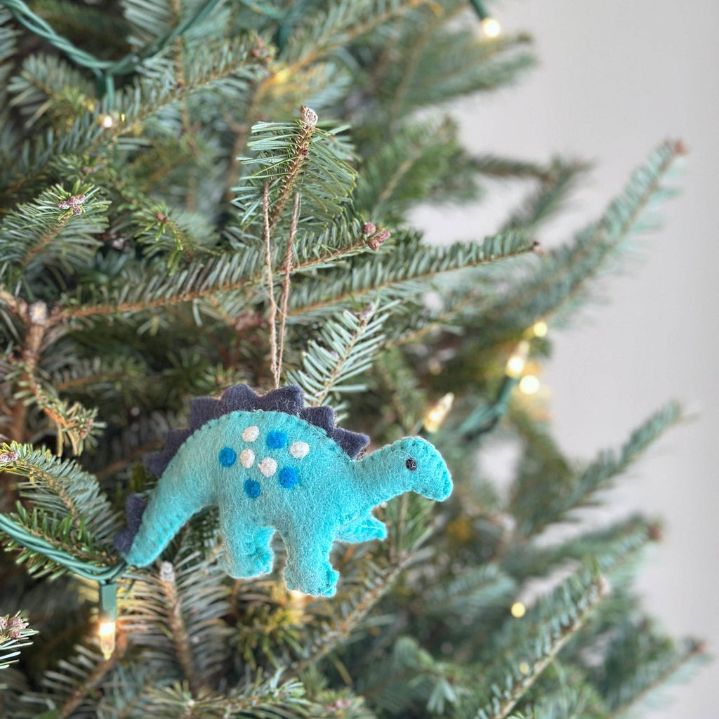 Get in the holiday spirit with our felt Christmas Stegosaurus! Made from eco-friendly wool felt and handcrafted in Nepal, this fair-trade ornament is perfect for decorating your Christmas tree. Designed in Florida, this cute and quirky ornament will add a playful touch to your holiday decor!