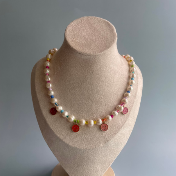 pearl necklace with pink smiley face charms and rainbow beads