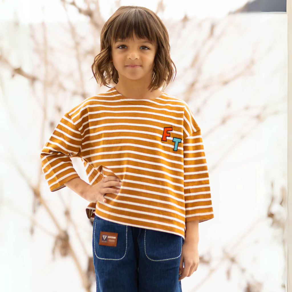 "Introducing our FITTEM Striped Overfit 3/4 Sleeve Tee—a versatile, comfortable staple every child's wardrobe needs. Designed to set a new standard in comfort and style, this tee is perfect for both boys and girls who seek the freedom to explore, play, and imagine.