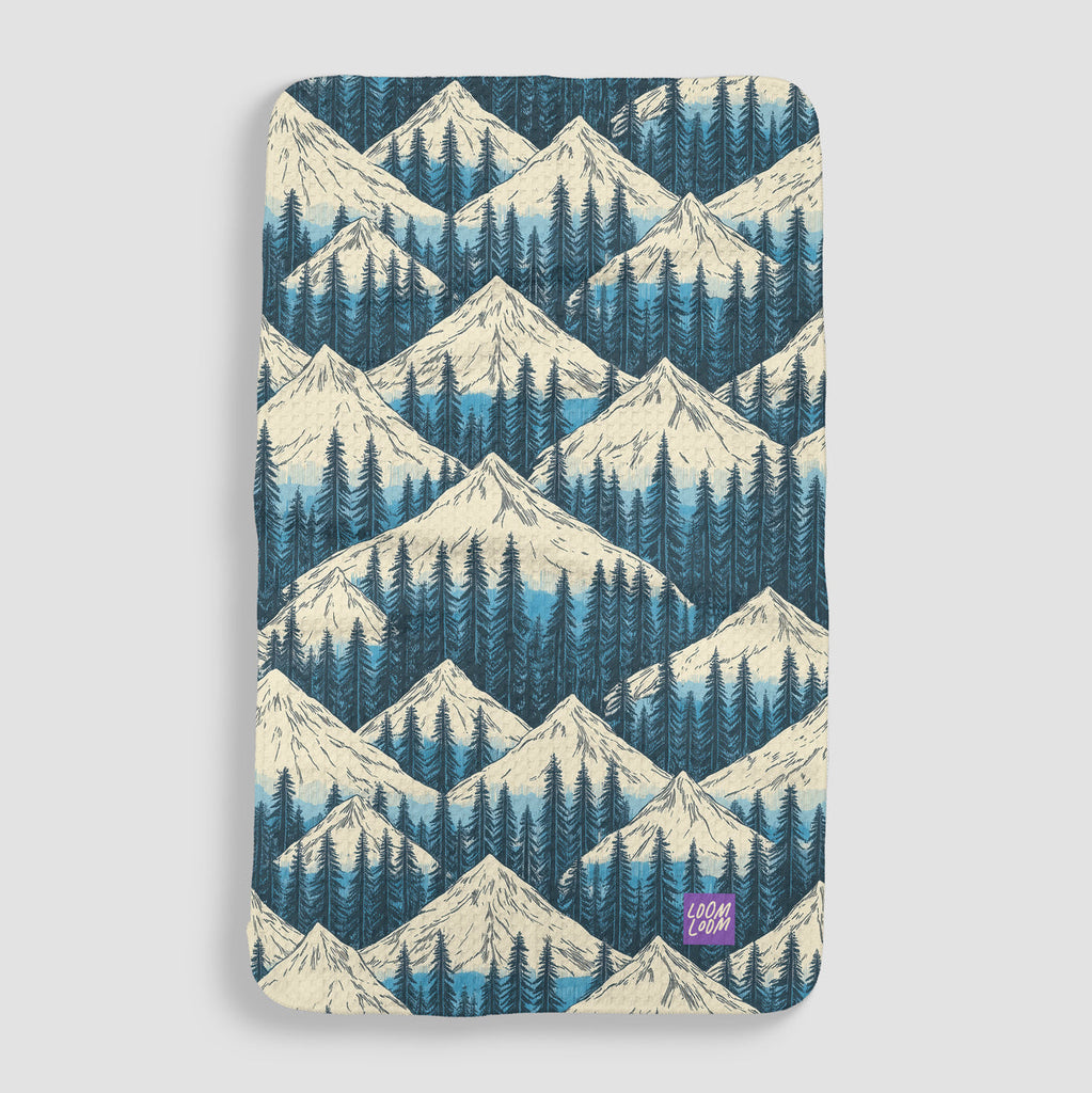 blue snowcapped mountain tops with pine trees