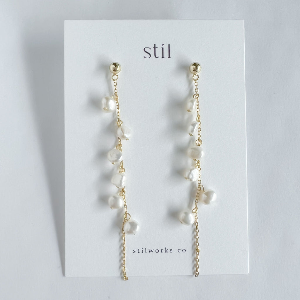 Add a touch of elegance and playfulness to any outfit with our Cascade Pearl Strand Studs. Each stud features a natural pearl delicately cascading from a gold plated steel strand. These unique studs are perfect for those who like to stand out with their accessories.