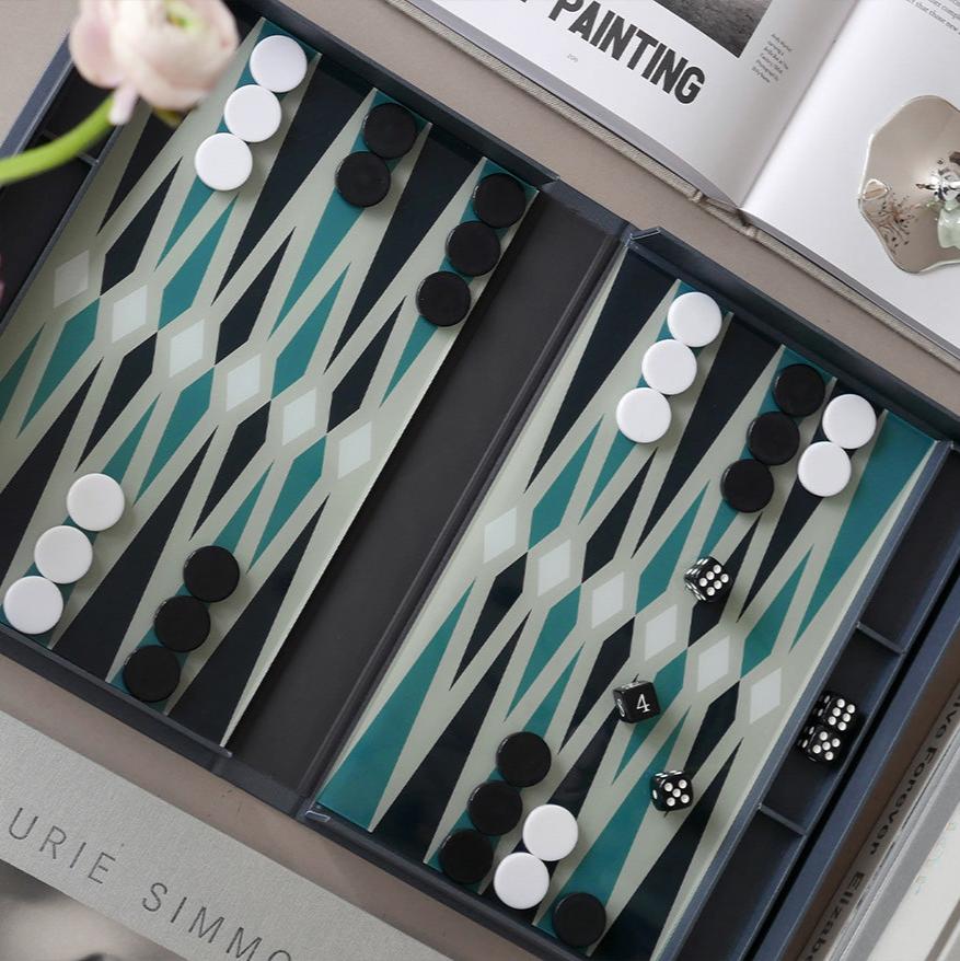 Our "Classic - Backgammon" opens like a book and features a sleek, thin layer of acrylic embellished with intricate patterns, inviting you to enjoy hours of strategic play. It also comes with easy-to-read instructions in English, French, and German. Suitable for two players and recommended for ages 5 and above.