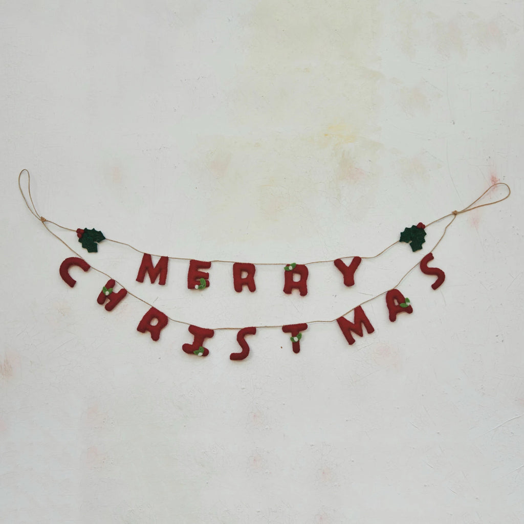 This handcrafted garland is a celebration of the holiday spirit, featuring lush wool felt holly leaves and bright red berries that spell out "Merry Christmas". Each element is meticulously created to bring a piece of the holiday cheer into the home.