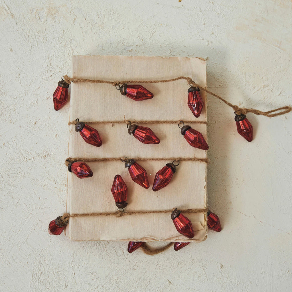 This mercury glass ornament garland on jute string is a beautiful way to infuse the space with holiday cheer. The rich red color of the mercury glass brings a warm, traditional feel to any setting, while the jute string adds a hint of rustic charm