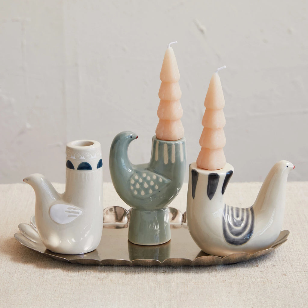 Add a touch of whimsy to your home decor with our Hand-Painted Dove Shaped Taper Holder. Each holder is uniquely hand-painted on stoneware, making it a one-of-a-kind piece. Perfect for adding a playful element to your candle display. White Wing