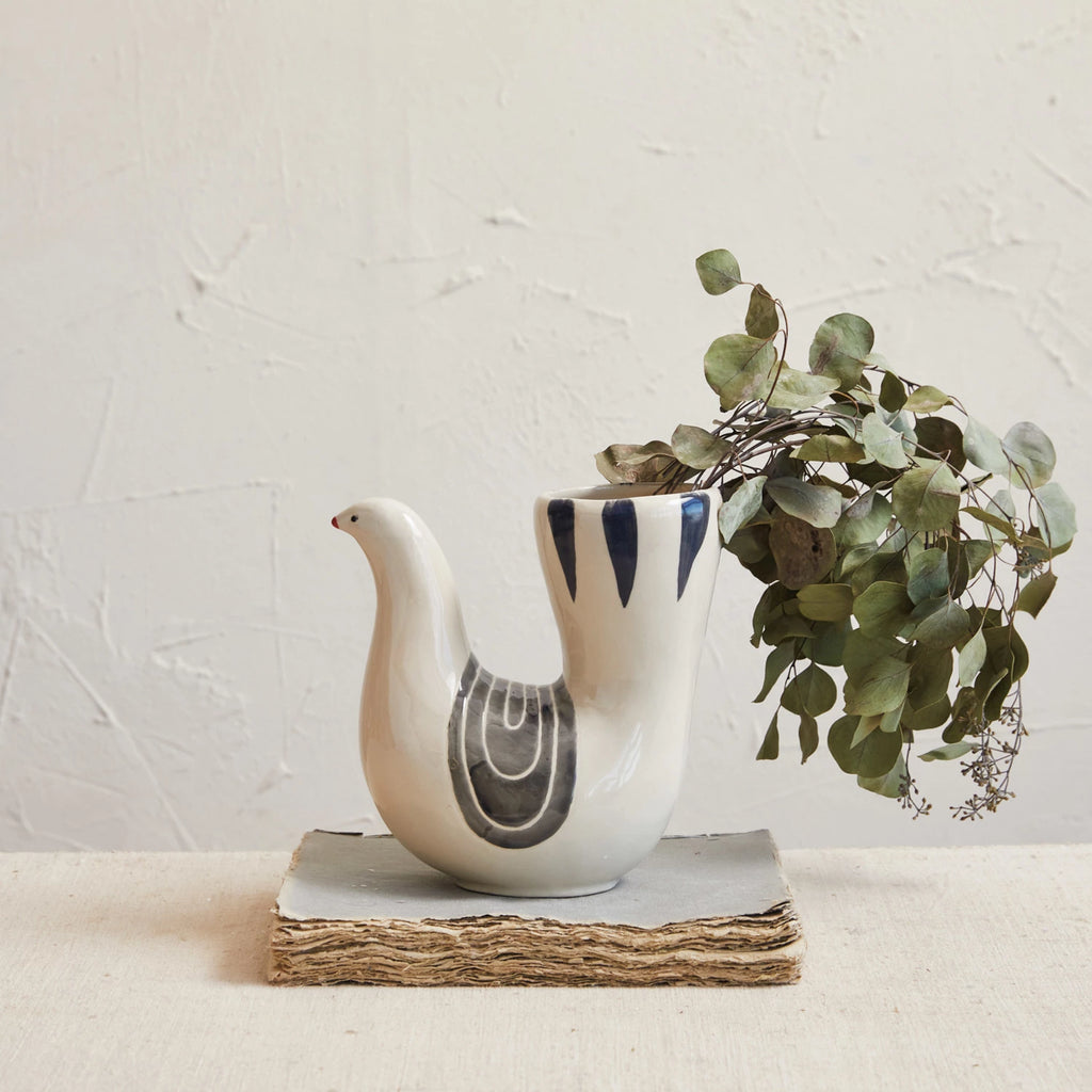 This hand-painted stoneware vase captures the essence of tranquility with its dove shape and a harmonious blend of white, grey, and blue hues. Its design evokes a sense of peace and elegance, making it more than just a vessel for flowers but a statement piece that enhances the decor of any room. Crafted from durable stoneware, it promises longevity and ease of maintenance, while its dimensions ensure it is a versatile addition to any interior