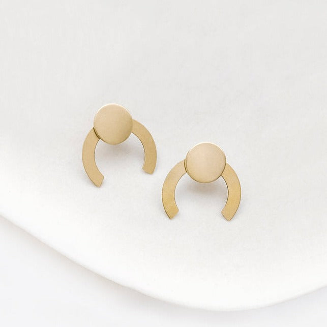 Enjoy the cosmic vibes with our Eclipse Jacket Raw brass and gold plated ear posts. These trendy earrings are perfect for adding some edge to any outfit. The raw brass adds a touch of rustic appeal, while the gold plating brings a touch of luxury. Shine on with our Eclipse Jacket earrings!