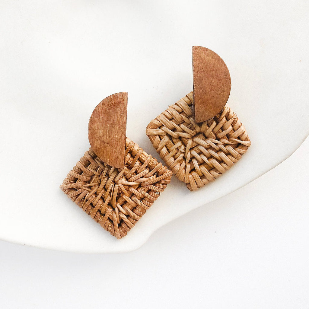 Add a touch of playful sophistication to your style with our Facet Earrings. Crafted from cognac stained pine and woven rattan, these earrings are finished with steel ear posts for a unique look. Elevate your everyday wardrobe with a hint of quirkiness.