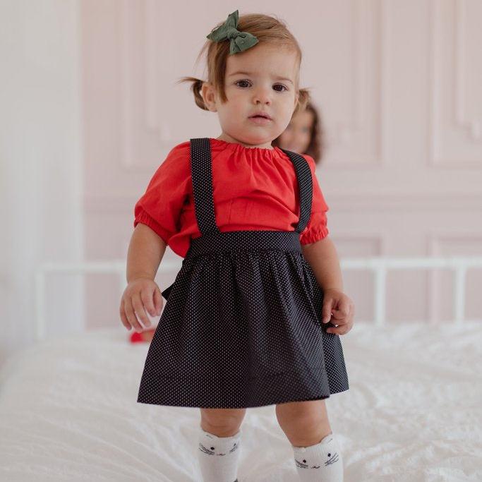 The Andi mini trouser skirt has adjustable suspenders with a button on the back. Two button holes are sewn on each suspender strap so your child can grow with their skirt making it easy to wear high on her waist when they are younger &amp; on their natural waist when older